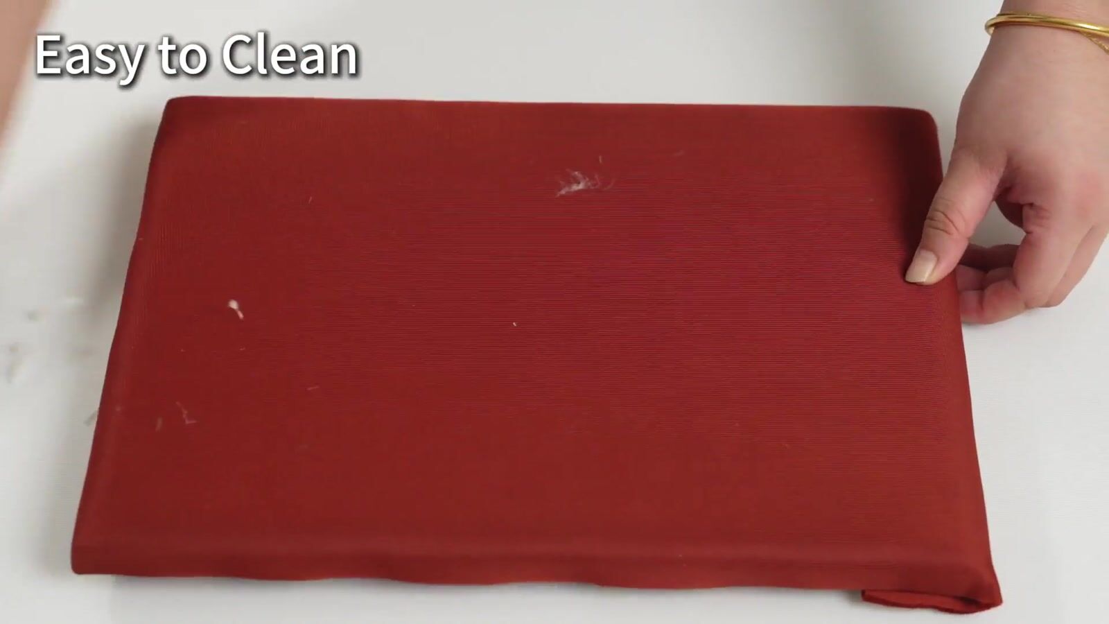 Loose crumbs on a red fabric-covered sample before wiping in the demonstration