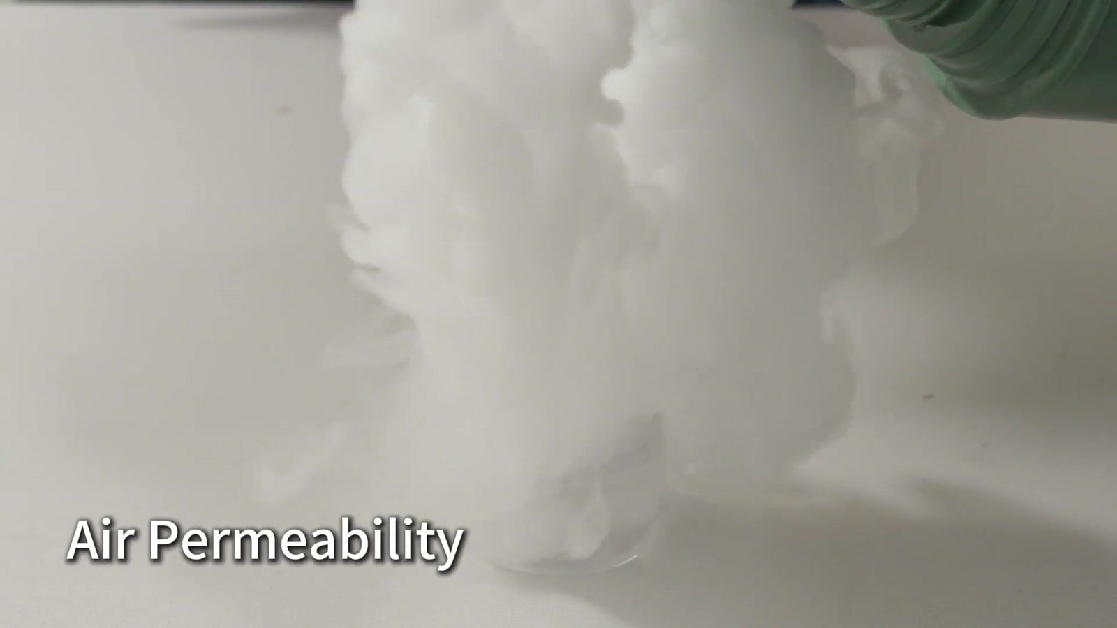 Mist passing through a white fabric sample held above a vapor source